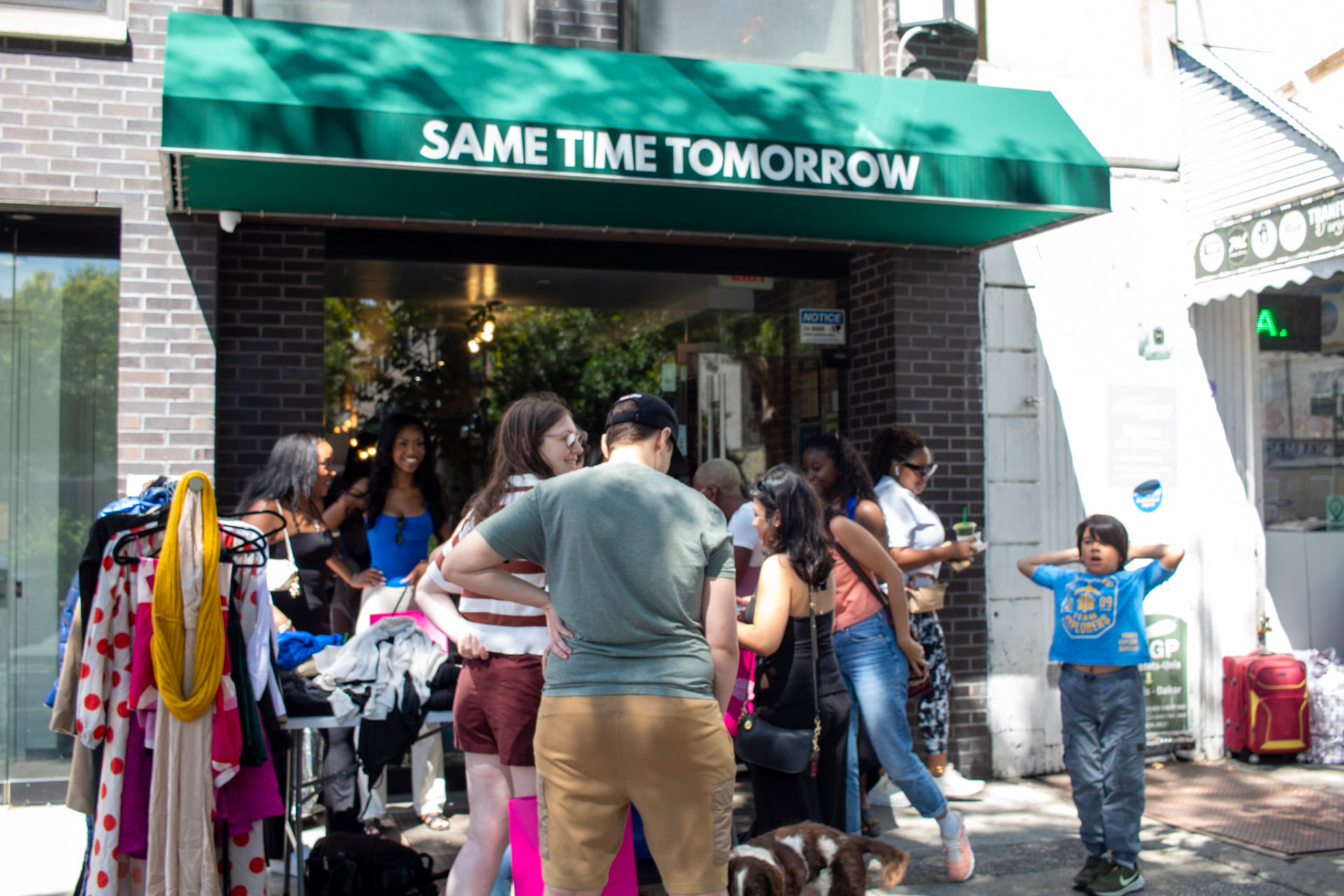 Community members browsing clothing racks outside Same Time Tomorrow