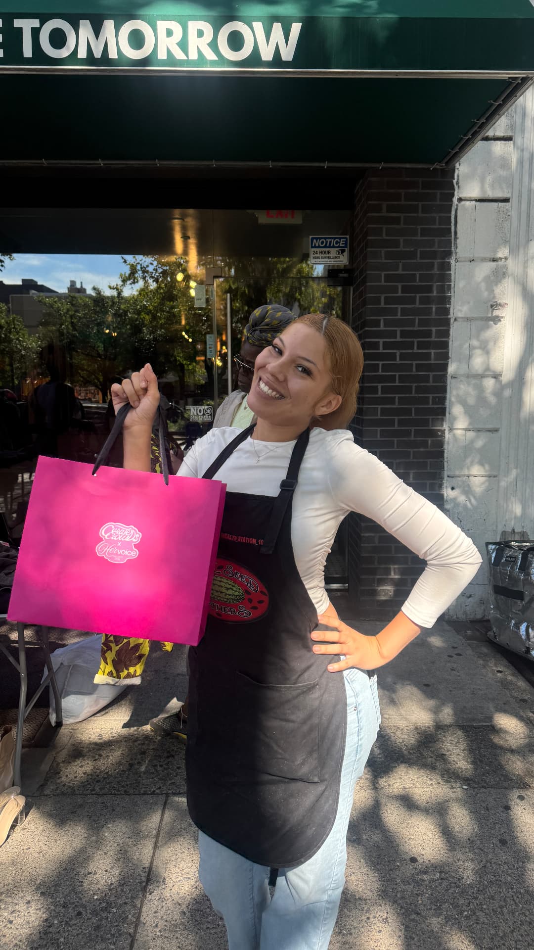 Same Time Tomorrow staff member holding a pink Her Voice Project bag